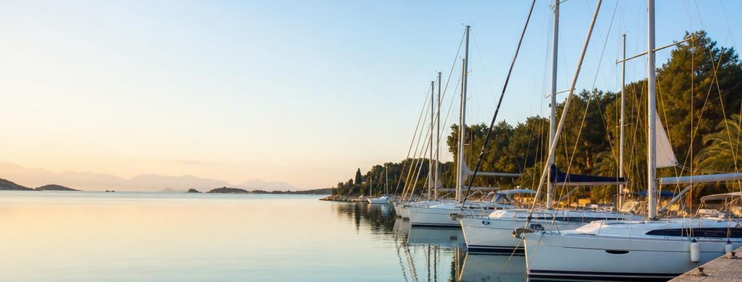 Segelyachten an einer Kaimauer in einer Adria-Marina im Morgenlicht (Symbolbild)